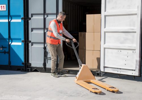 full-shot-man-carrying-pallet-truck